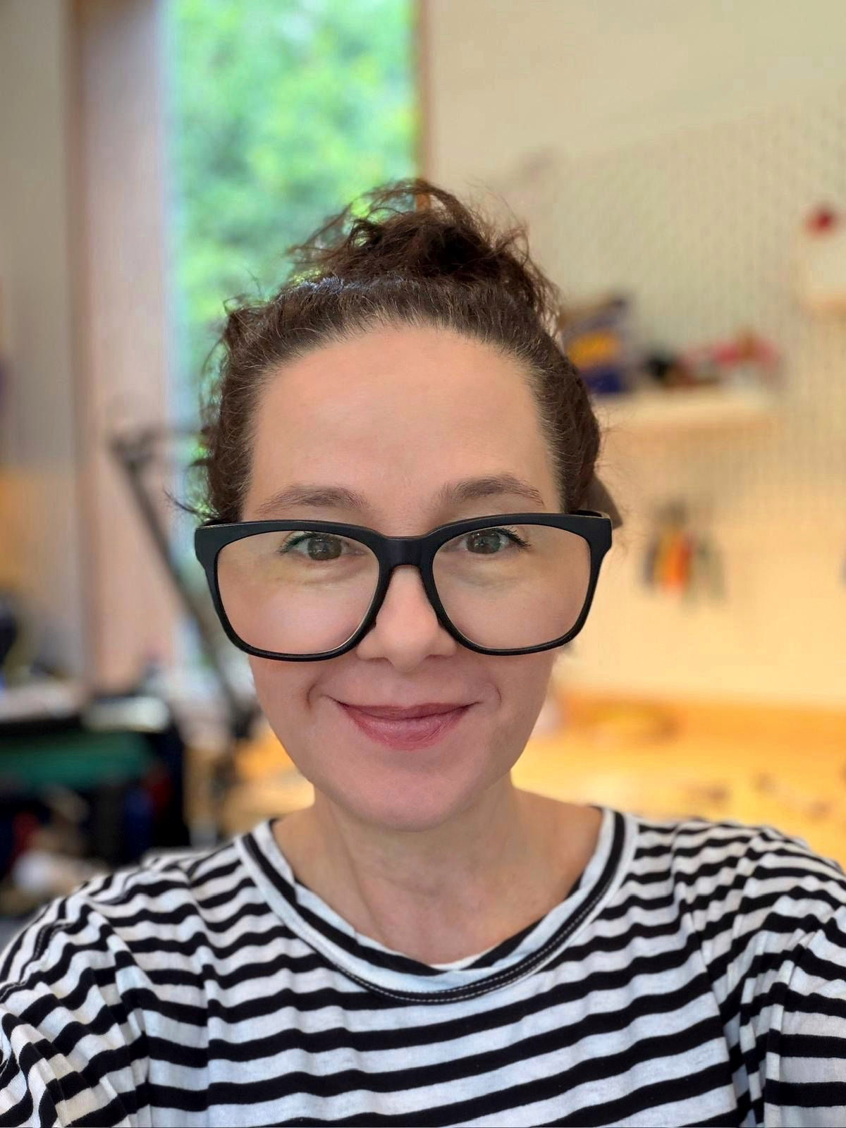 Jewellery designer Regina Krawets in front of her workench in her Northern Sydney garden studio where she crafts architectural sterling silver and gemstone jewellery.